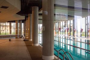 科沃布热格Seaside Apartaments Deluxe 627的一座建筑物内一座带柱子的游泳池