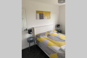 斯托诺韦The Gallafield, Self Catering Bungalow , Stornoway的一间卧室配有一张黄色和灰色枕头的床