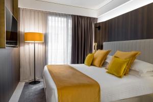 里乔内We Me Suite Hotel的一间卧室配有一张带黄色枕头的大床