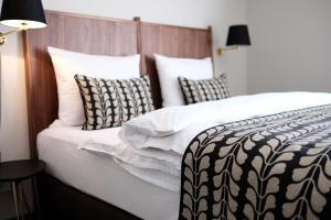 慕尼黑Parkhotel Obermenzing的一张配有黑白床单和枕头的床