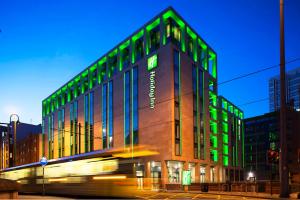 曼彻斯特曼彻斯特城市中心假日酒店的建筑的一侧有绿灯