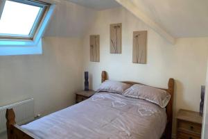 利明顿New Forest Spacious 2 bed flat的卧室配有一张墙上有两张照片的床。