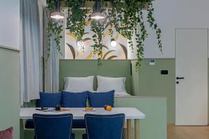 雅典Acro Urban Suites的一张带蓝色椅子和植物的餐桌