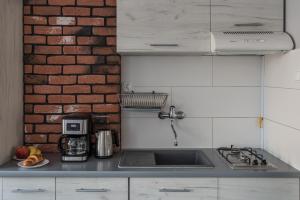 华沙Magnetic apartment Jerozolimskie A的厨房设有水槽和砖墙
