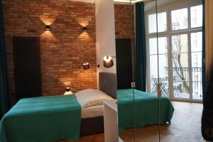 波兹南My Place in Poznan Centrum的一间卧室设有绿色的床和砖墙