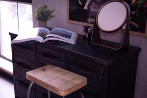 诺里奇31B Urban Stays的一张带镜子的桌子、一本书和一张凳子