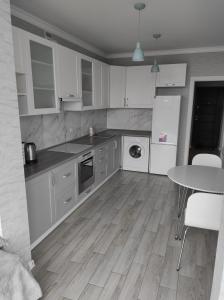 赫梅利尼茨基Апартаменти Люкс2的厨房配有白色橱柜和桌子