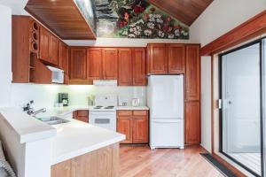 惠斯勒Rainbow by Outpost Whistler的厨房配有木制橱柜和白色冰箱。