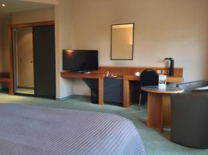 赫林贝亨修道院酒店 的酒店客房配有一张床和一张书桌及一台电视