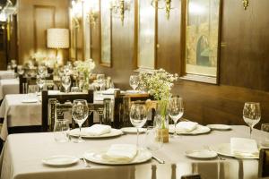 罗德里戈城Hotel Conde Rodrigo 2的用餐室配有带白色桌布和酒杯的桌子