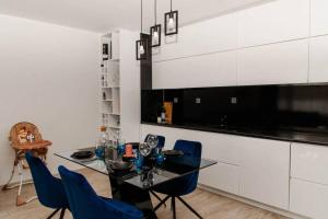 旧扎戈拉Super luxurious & spacious designer apartment.的一间用餐室,配有黑桌和蓝色的椅子