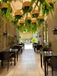 科恰班巴Hotel Catena的一间设有桌椅的餐厅,种植了植物