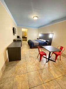 麦卡伦Texas Inn & Suites McAllen at La Plaza Mall and Airport的卧室配有一张床和一张桌子及椅子