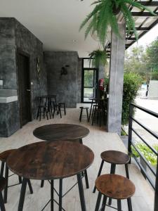 Sangkhomเคียงภูวิลล่า的配有桌椅的客房内设有两张桌子和凳子