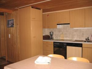 格林德尔瓦尔德斯图兹1号小木屋酒店的厨房配有木制橱柜和桌椅