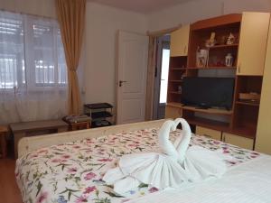 布什泰尼Casa Farcaș Bușteni的一间卧室配有一张睡床,其中有两只天鹅