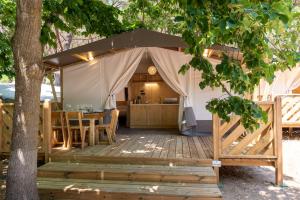 卡斯蒂里昂纳·德拉佩桑塔波马特露营地的木制甲板上的帐篷,配有桌椅