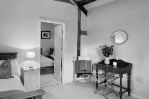 克雷文阿姆斯Upper Heath Farm - Stable Cottage的一间卧室配有一张床、一张书桌和一面镜子