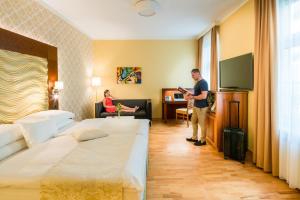 维也纳杰斯霍夫阿姆拉特斯酒店的站在酒店房间,带两张床的男人