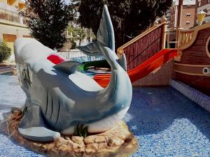 卡里拉Hotel Bon Repos的游乐场滑梯上的鲸鱼雕像
