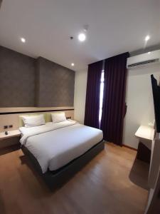 巴淡岛中心Blitz Hotel Batam Centre的卧室配有一张白色大床和一张书桌