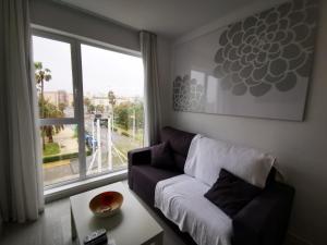 瓦伦西亚Sol Playa Suites的带沙发和大窗户的客厅