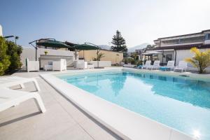 卡普多兰多Villa Concettina的一个带白色躺椅的游泳池和一个游泳池