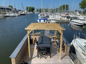 乌伊斯特勒昂Magnifique bateau maison的水面上配有桌椅的木制码头