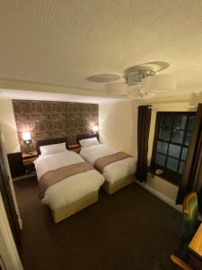 巴纳德城堡The Redwell Inn的酒店客房设有两张床和窗户。