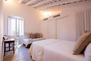 巴塞罗那CASA FILOMENA的一间白色卧室,配有两张床和窗户