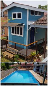 Kampong Baharu Sungai UdangTiny House B&B的蓝色的房子,前面设有一个游泳池