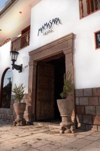 库斯科Mamasara Cusco的拥有两株盆栽植物的酒店入口
