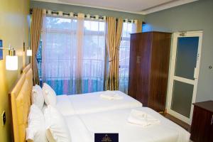 纳纽基HOTEL TAJI的一间卧室设有两张床和大窗户