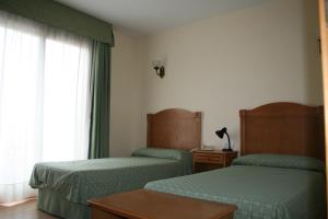 波多黎多德萨贡托奥地利76号酒店的酒店客房设有两张床和窗户。