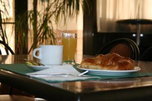 波多黎多德萨贡托奥地利76号酒店的一张桌子,上面放着一盘面包和一杯橙汁
