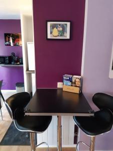 谢西Briget Apartment的紫色墙壁的房间一张桌子和四把椅子