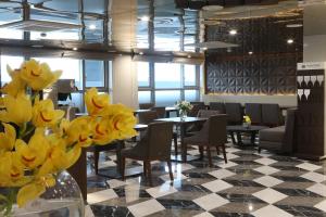 釜山阿文特里釜山酒店的一间带桌椅的餐厅,并种植了黄色的鲜花