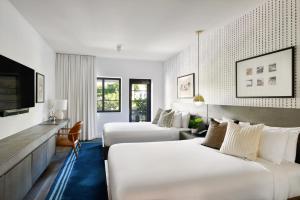迈阿密海滩Kaskades Hotel South Beach的一间酒店客房,设有两张床和电视