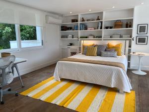 帕拉蒂Tropical Contemporary Suites的一间卧室配有一张床、一张书桌和一个窗户。
