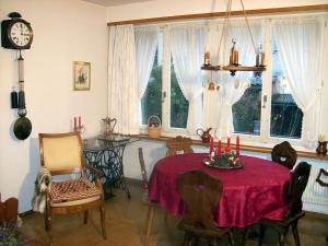 巴塞尔切斯珍黛丝住宿加早餐旅馆的一间带桌椅和时钟的用餐室