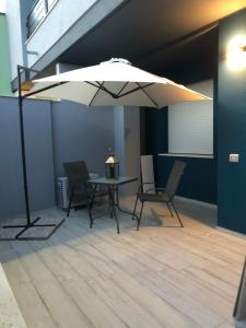 DecimomannuNuovo appartamento Elegante,curato nei dettagli的桌子、椅子和雨伞