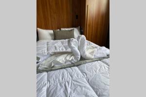 匹兹堡3E-Cozy! Micro apartment! in Oakland, sleeps 1的一张带白色床单和枕头的未铺好的床