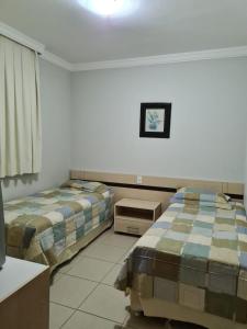 热河市Rio Quente Aguas da Serra Apart的一间卧室配有两张床、一张桌子和一面镜子