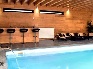 罗伯特维尔Luscious Holiday Home in Waimes with Pool Sauna的客房设有游泳池、椅子和桌子。
