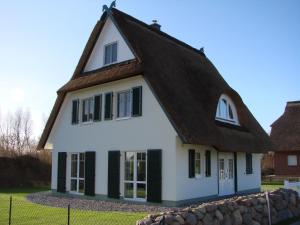 奥斯特巴德里克Fairy tale holiday home in Rerik with private terrace的一间白色的小房子,有棕色的屋顶