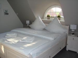 奥斯特巴德里克Fairy tale holiday home in Rerik with private terrace的白色的床、白色枕头和窗户
