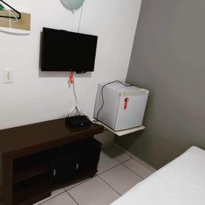 波多韦柳Pousada Surya的一间卧室配有电视和一张带电脑的书桌