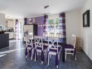 奥斯特巴德里克Thatched Holiday Home in Rerik with Terrace的厨房以及带紫色墙壁和桌椅的用餐室。