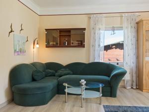 京斯特Elegant apartment with garden in Gingst的客厅配有绿色沙发和桌子