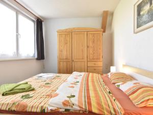 奥斯特巴德里克Spacious Apartment in Rerik Germany near Sea的一间卧室配有一张床和一个木制橱柜